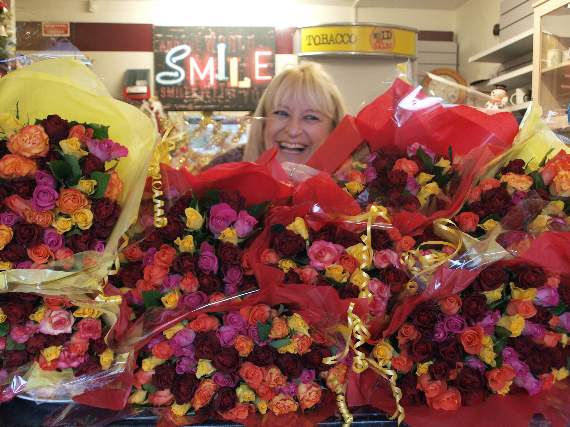 Wendy Norman in her heyday at the bus station kiosk, receiving a gift of hundreds of roses.