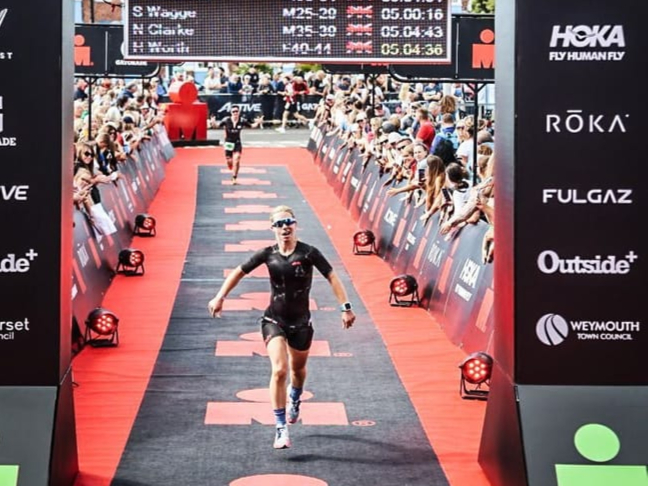 Hannah Worth reaches the finish line after the Weymouth Half-Ironman event.