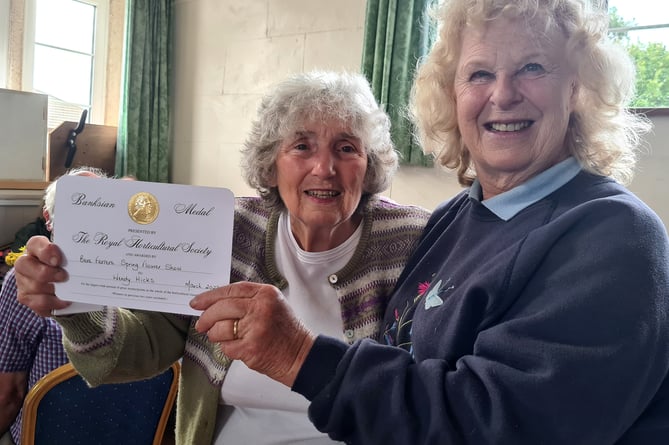 Wendy Hicks, left, receives her RHS Banksian Medal from Bere Ferrers Flower Show president Dr Howard 