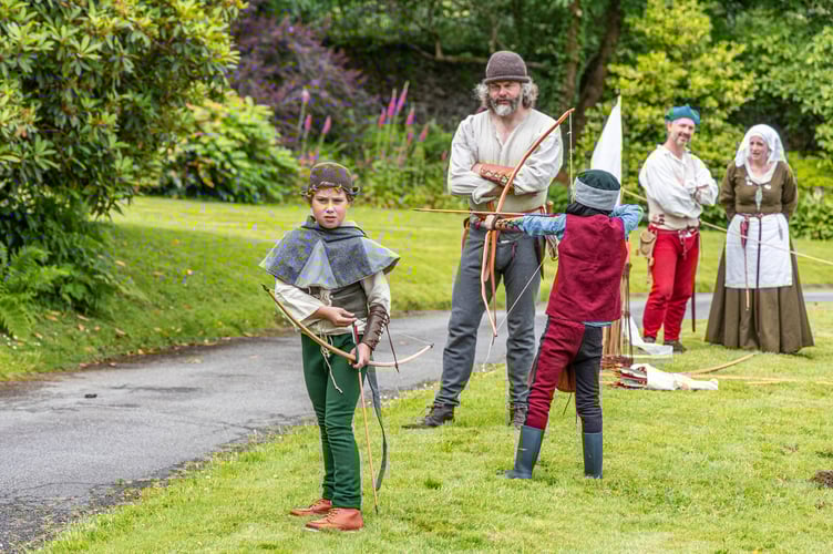 Dads and sons dressed in Medieval costume at a Fathers' Day event at Buckland Abbey