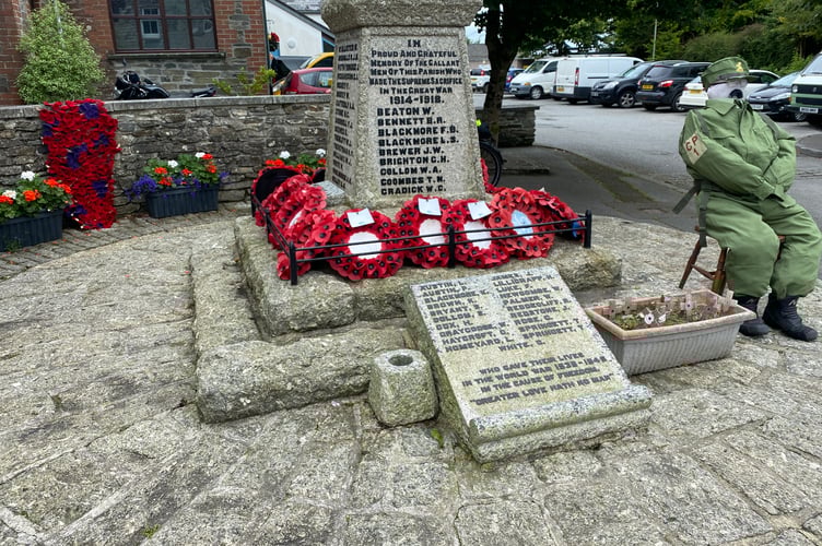 A military scarecrow keeps vigil at the village war memorial for Bere in Bloom.