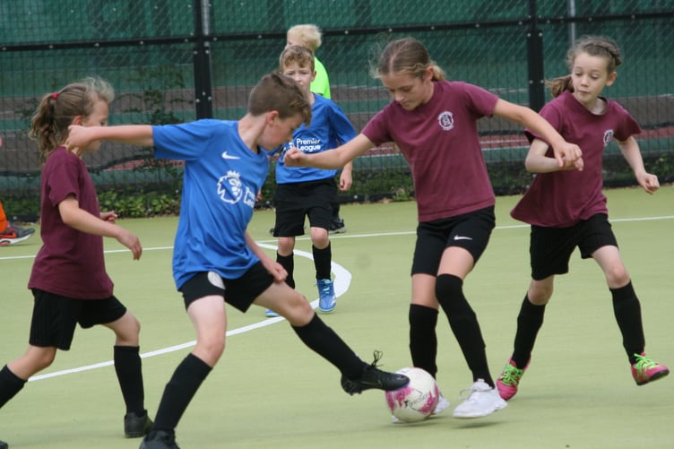 Avoiding the tackles at the hard-fought West Devon Primary Schools Mixed Football Tournament.