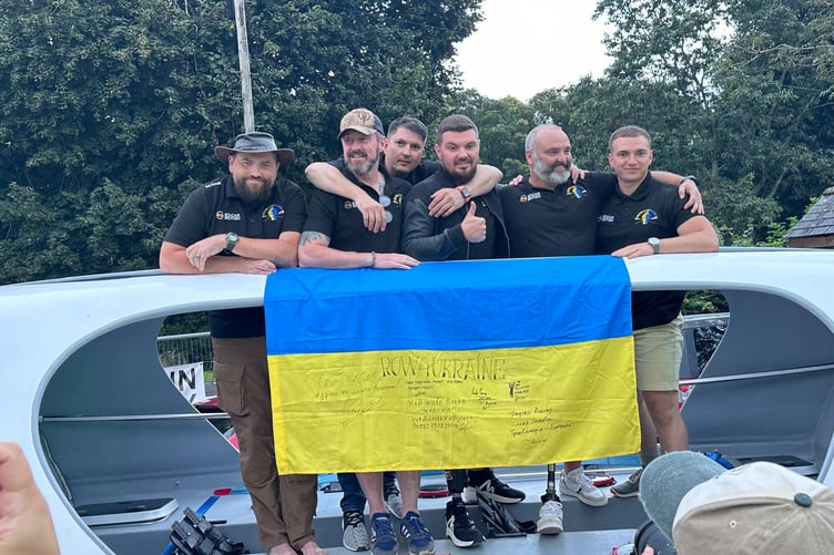 Lee Spencer and his team of wounded Ukrainian rowers with their boat.