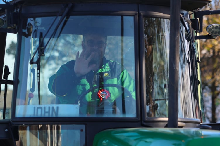 John waves at the spectators as he joins the tractor rally which ended up in Yelverton for a rally.