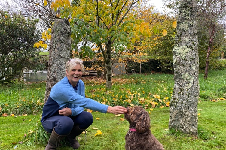Annie Charles and her dog Rosie with the standing stones in her moorland garden where she runs the garden therapy project Blooming Well