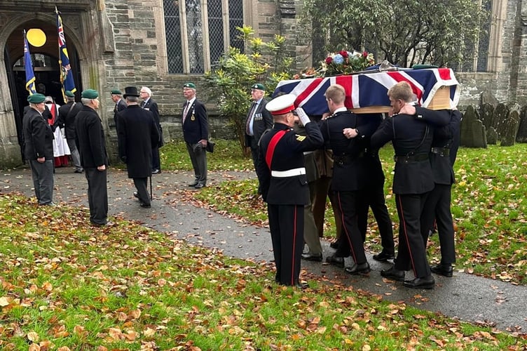 Royal Marines pall bearers with the coffin draped with the Union Flag and a guard of honour at the funeral of Lt Peter Cameron at St Eustachius' Church, Tavistock.