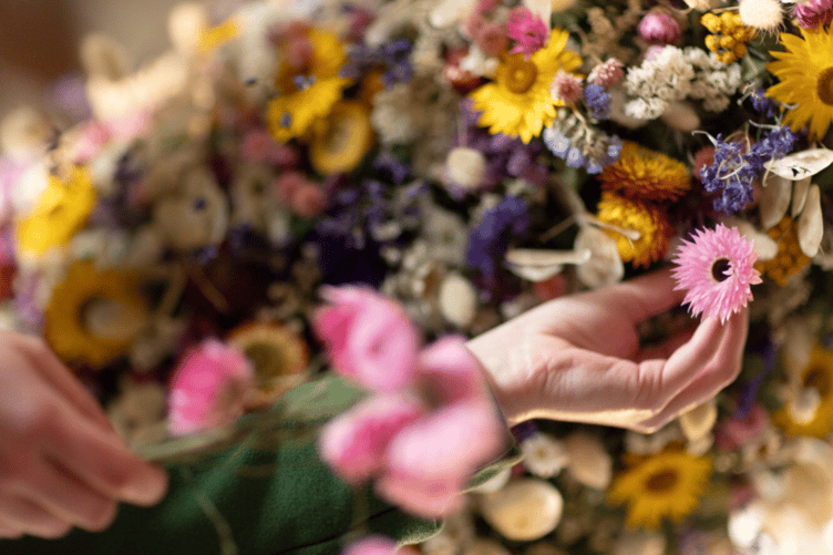 National Trust Cothele's famous Christmas garland slowly takes shape with dried flowers attached.