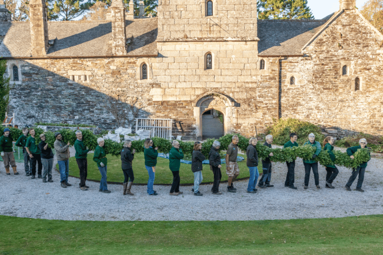 First the greenery is hung for the dried flowers to be attached to as the Cothele National Trust Christmas garland takes shape.