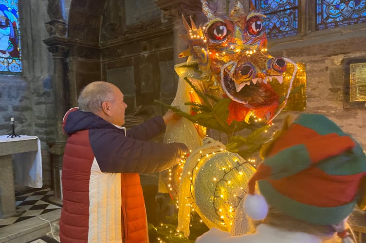 Breathing fire on the Tavistock Musical Theatre Company tree at Tavistock Christmas Tree Festival. Julian Bennett and elf Paula Smith decorate.