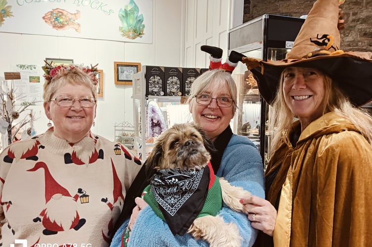 Tavistock Pannier Market thrives despite the stormy weather. Pictured are Paula Robert (customer) Colette David (of Colton Rock) and Kay Gawman (witch of Christmas future) .