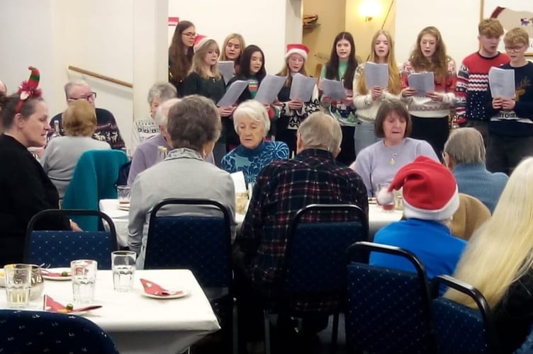 Members of Tavistock Memory Cafe enjoy carol singing at their Christmas party by Tavistock College students 
