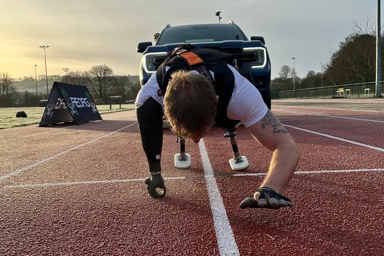 Afghan veteran Marine Mark Ormrod inching his way along the Tavistock College running track pulling a vehicle.