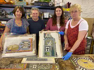 The Tavistock community mosaic undergoing painstaking repairs by volunteers with tutor Andy Cairn (second left).