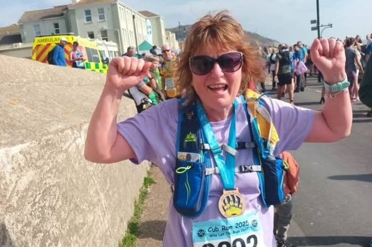 A euphoric Dotty King celebrates finishing a tough ten-mile cross country race a few months after battling cancer and major surgery.
