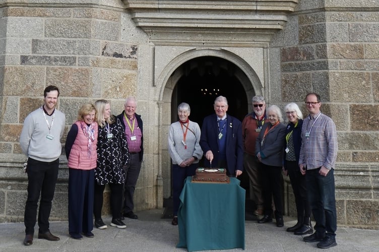 Staff and volunteers cutting a cake celebrating 50 years of being open to the public.
