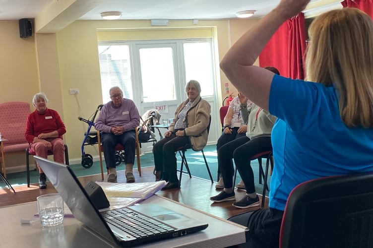 Cathy XX instructing people living with dementia in exercises good for the brain and body at TASS inTavistock. 