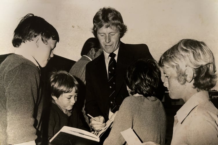 Peter Lever signing autographs for local children.