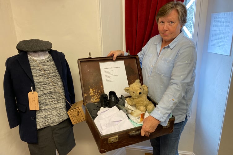 Sally-Ann (Tavistock Museum visitor experience officer) showing off the child evacuee suitcase at the museum'sVE Day exhibition. 