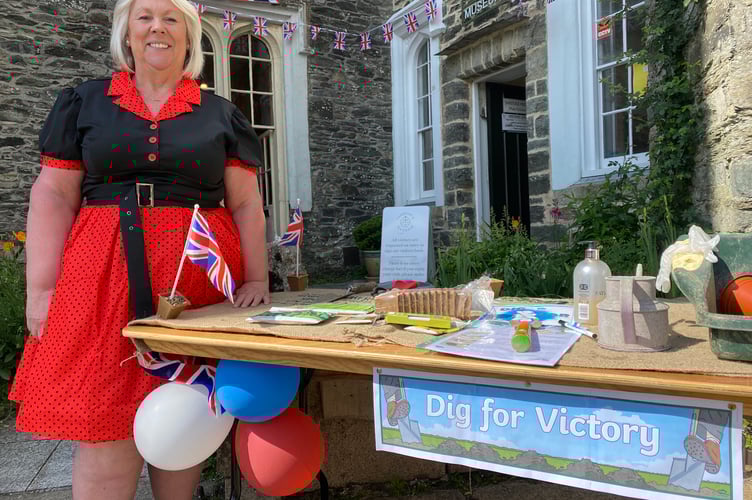 Tavistock museum manager Lesley Holliday in her 1940s style dress with the museum's dig for victory attraction as part of the town's VE Day 80 events.