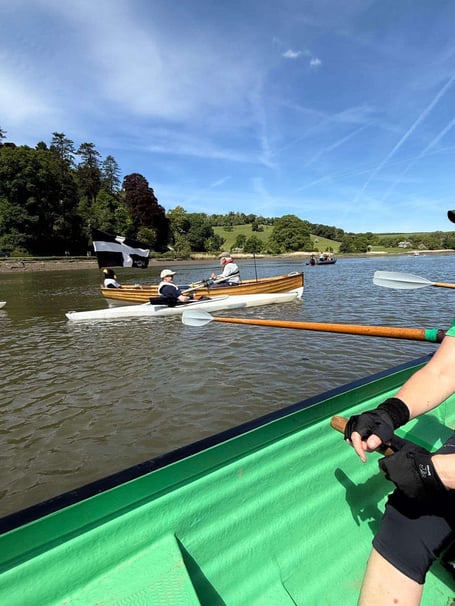 A team of rowers from Cotehele Quay Gig Club row out to join the flotilla of boats to greet explorer Robin Hanbury Tenison at the end of the first leg of his rowing challenge. (Picture: Kim Lakey/Cotehele Quay Gig Club)