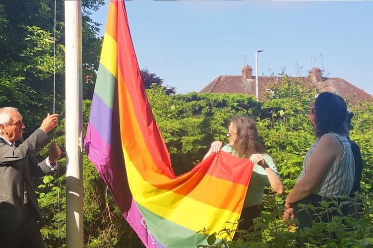 The LGBTQ+ flag being raised in Exeter.