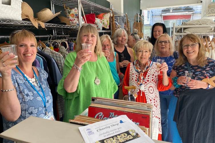 TASS charity shop staff and volunteers celebrate the re-opening in a new unit after a flood.