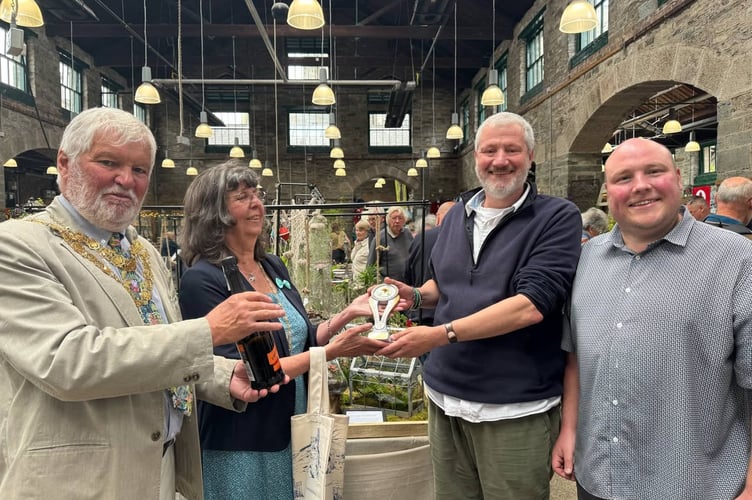 The Artisan Merchants won the best show garden at Tavistock Garden Festival. They are presented with their prize and trophy by town mayor and consort Cllr Steve Hipsey and his wife XX