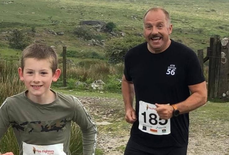 Princetown Firefighters 10km race with two smiling runners.