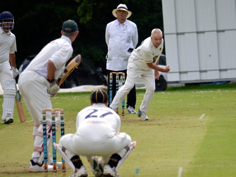 Tavistock's veteran bowler Andy Gauler – 61 and still wheeling away – coming in down the hill against Cornwood