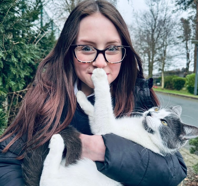 Dusty the cat with one of her humans back home on the Isle of Man.