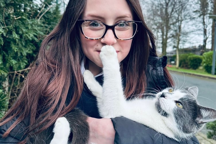 Dusty the cat with one of her humans back home on the Isle of Man.