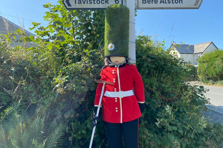 A Grenadier Guard soldier standing guard as a scarecrow in the Bere Alston In Bloom competition.