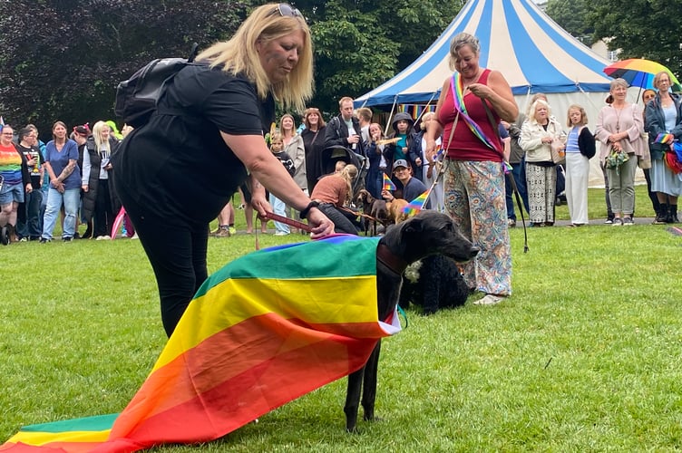 Proud pet owner with her dog dressed to impress a Tavi Pride's dog show in the best Pride accessory class.