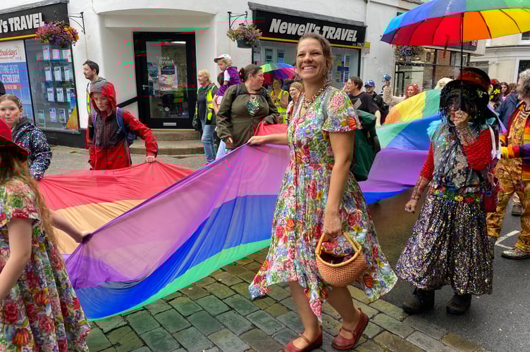Colourfully dressed marchers and giant pride flag on Tavi Pride procession.