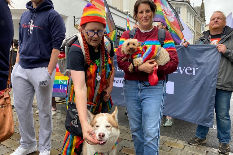 A couple and their dogs, all dressed for the occasion, in Tavi Pride's town centre procession.