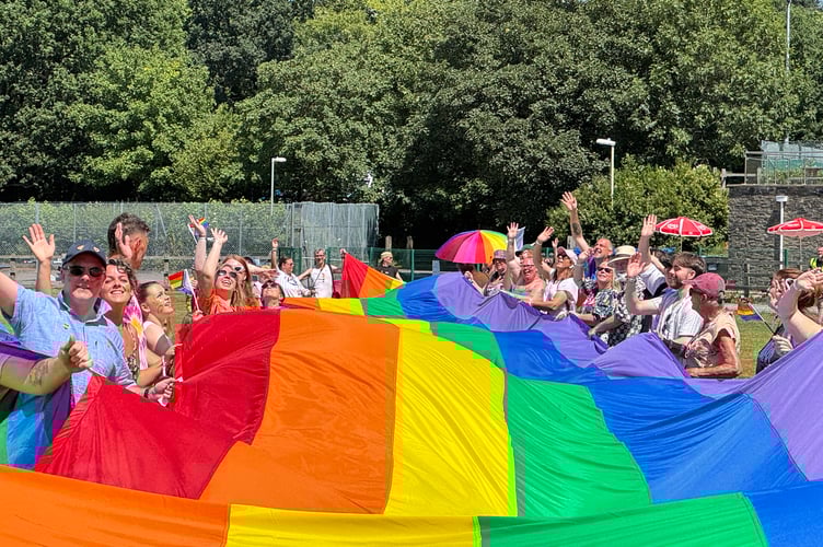 Holding the giant rainbow flag at Okehampton Pride. AQ 6510