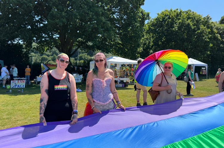 Holding the giant rainbow flag at Okehampton Pride. AQ 6519