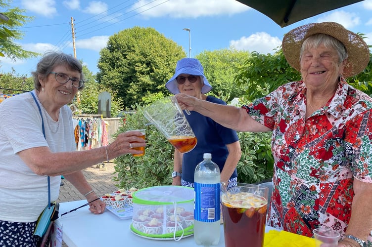 Resident Jenny Eglington serving neighbour Lillian Jones with Pimms during a summer fair at their shared home in Drake Lodge, on Plymouth Road Tavistock.