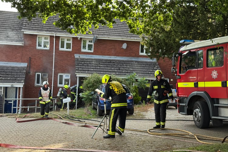 Firefighters in breathing apparatus about to enter the property on fire in Crediton.  AQ 7763
