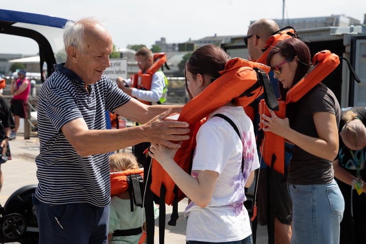 Visitors get kitted out for a boat ride at Devonport Open Days.