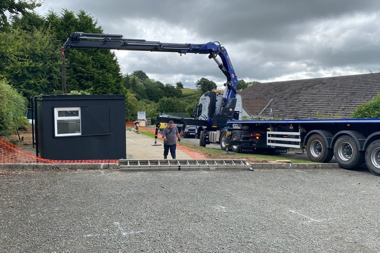 Harrowbarrow receives a very special delivery as the cabin, soon to be home of the Tamar Valley Pantry, is craned onto site. (Picture: Karen Bennett)