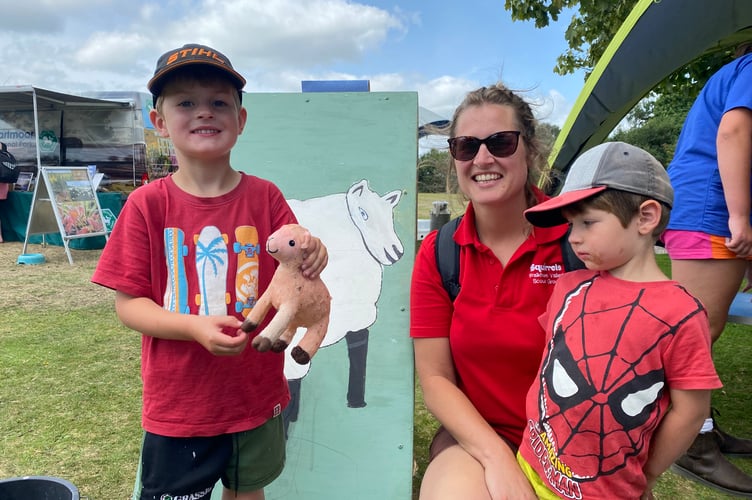 Rachel Arrowsmith, of Postbridge, with her sons Peter, 5, and Henry, 3, learning some simulated lambing at Yelverton Fun Day. They are pictured on the Roborough Young Farmers stand.