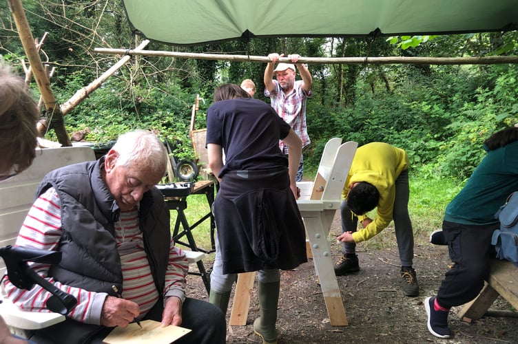 Intergenerational action with Tavistock Memory and Tavistock Youth cafes learning skills and sharing memories on a day in the woods. Picture by Heather Rayne.