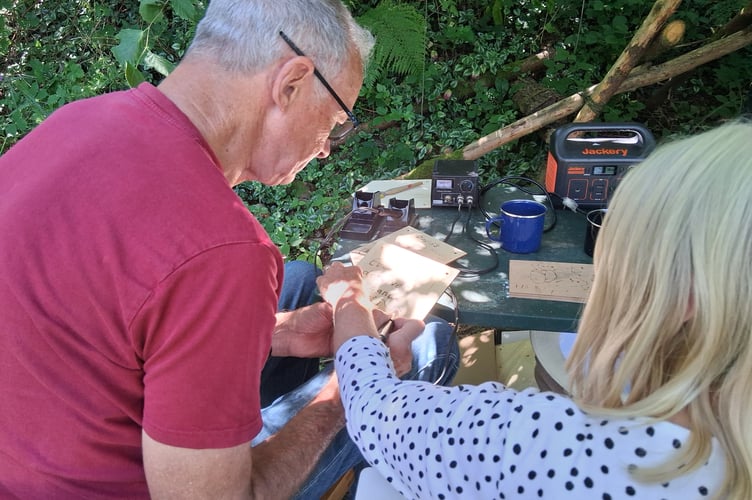 Tavistock Youth Cafe members with a fellow guest from Tavistock Memory Cafe on an 'away day' to share and learn artistic skills such as pyrography (pictured) and memories. Picture by Heather Rayner.