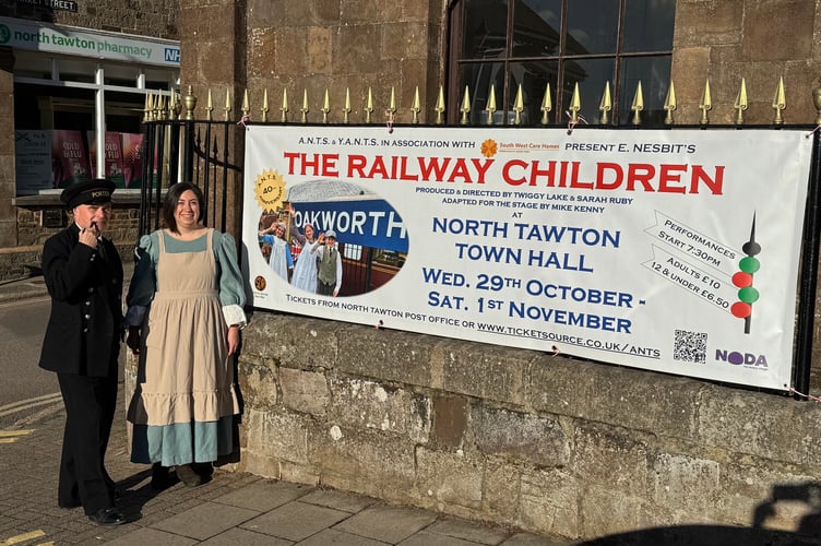 Nigel Davies as Perks and Sarah Ruby as Mrs Perks pose for a picture beside the ANTS banner outside North Tawton Town Hall. AQ 4180