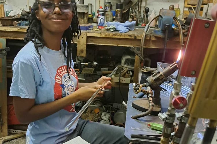 One of award-winning master glassblower Graham Reed's recent trainees from London in his Bere Alston studio.