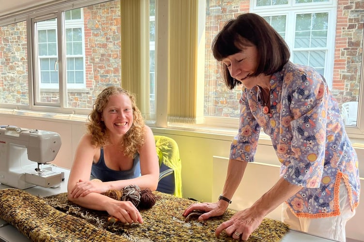 Members of the Okehampton Repair Café mending a rug.