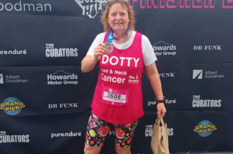 Seasoned runner Dotty King celebrating finishing her first half marathon race on her comeback from conquering cancer.