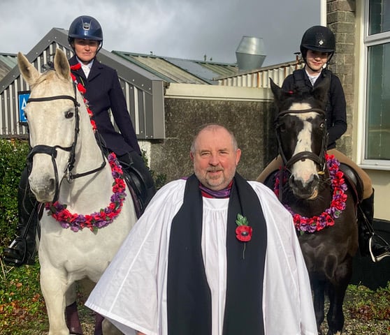 The Ven Nick Shutt and two horses with remembrance garlands at Walkham memorial parade. Picture by Bunty Baxter.