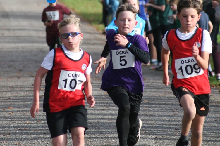 Two runners from Okehampton split by a Mary Tavy & Brentor runner at the finish of Castle Drogo cross country. Picture by Mhairi McCall.